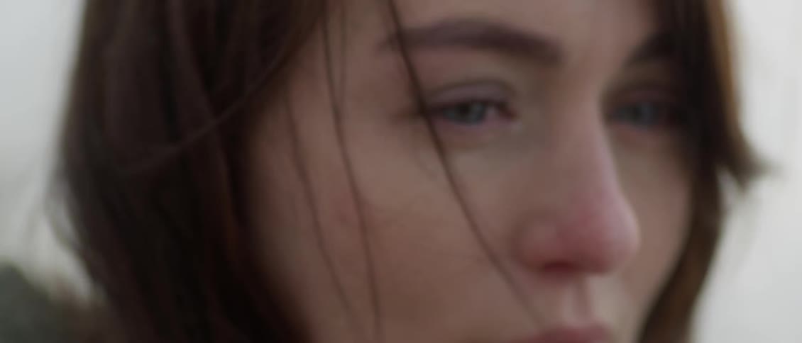 The wind blows a woman's hair around her face