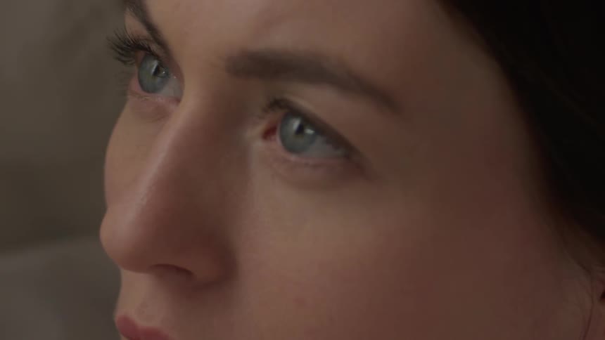 A woman looks ahead and then blinks