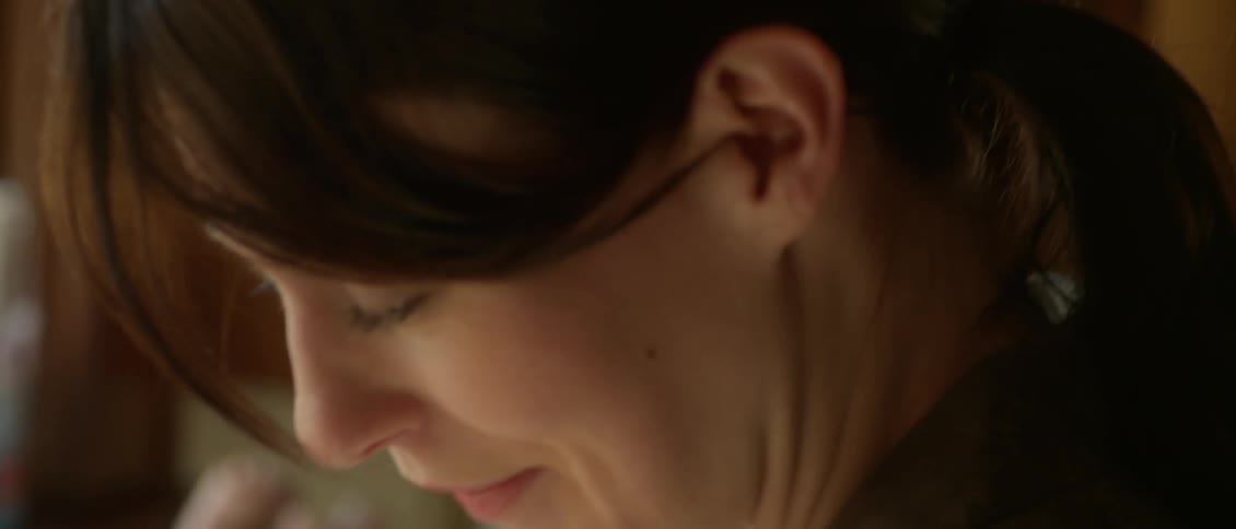 A woman smiles looking down