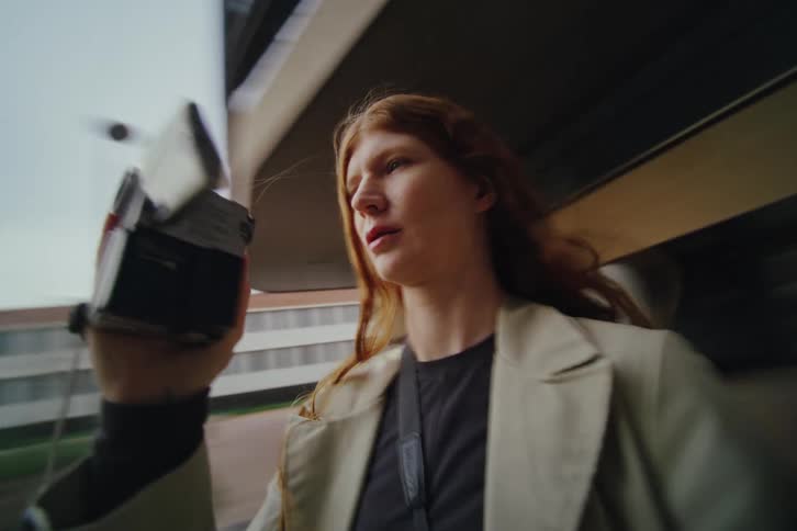 Woman holds a camera while walking in an urban area