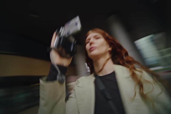The woman spins while filming the building