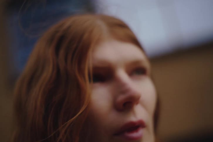 Young woman holds her camera to her face as she takes a picture