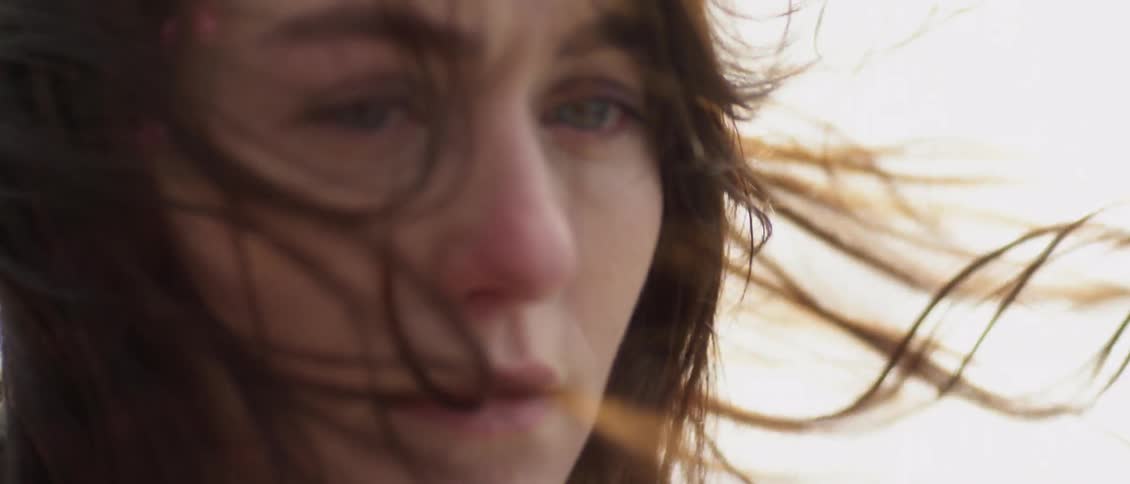 Woman stares outside on a windy day