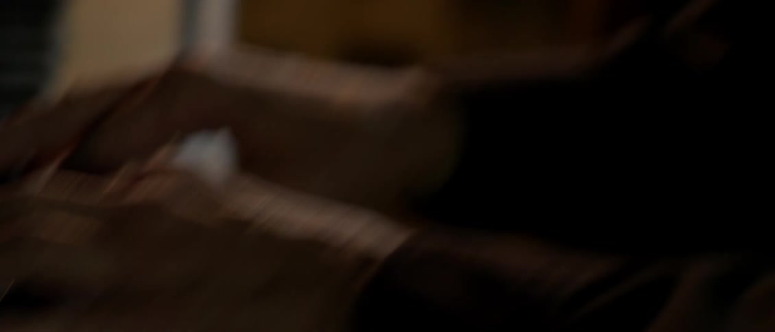 A man wearing glasses plays the piano