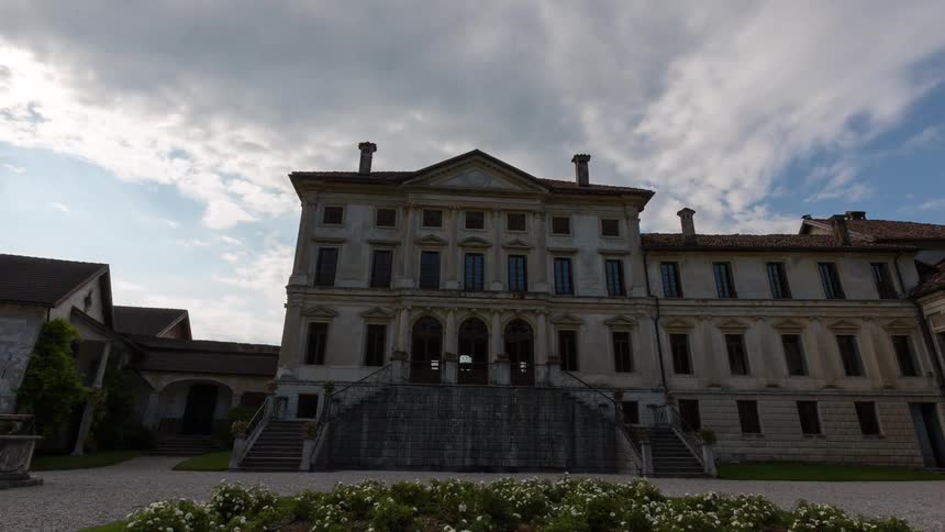 Historic palace with central staircase in front of a circular garden