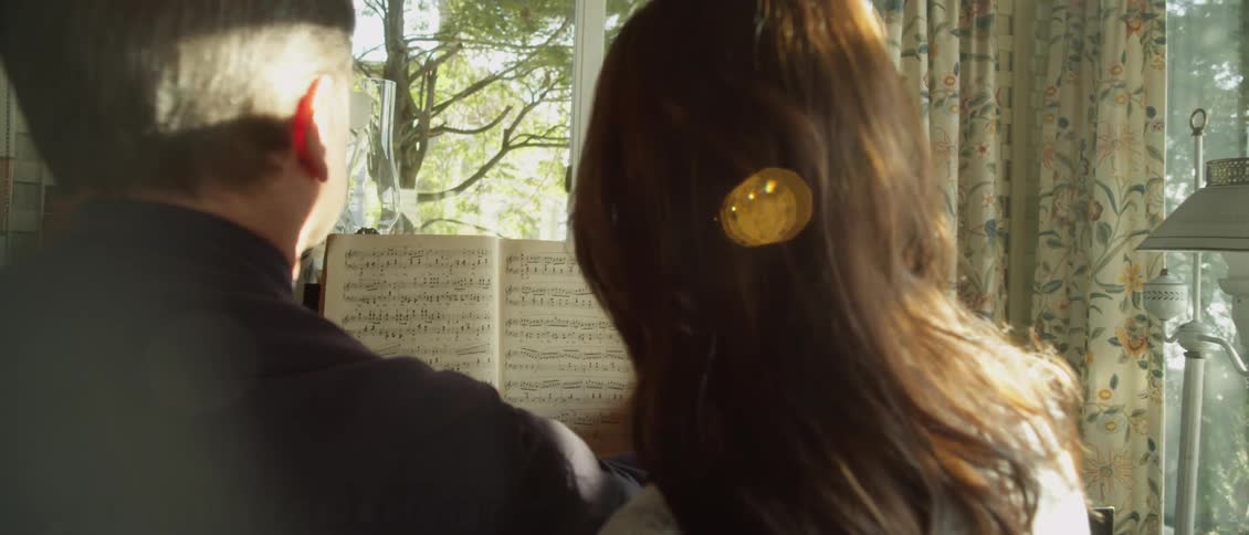 Man and woman look at sheet music together
