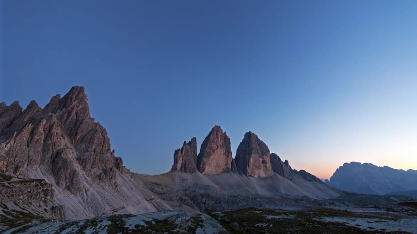 Rocky peaks stand out under a blue sky at dusk