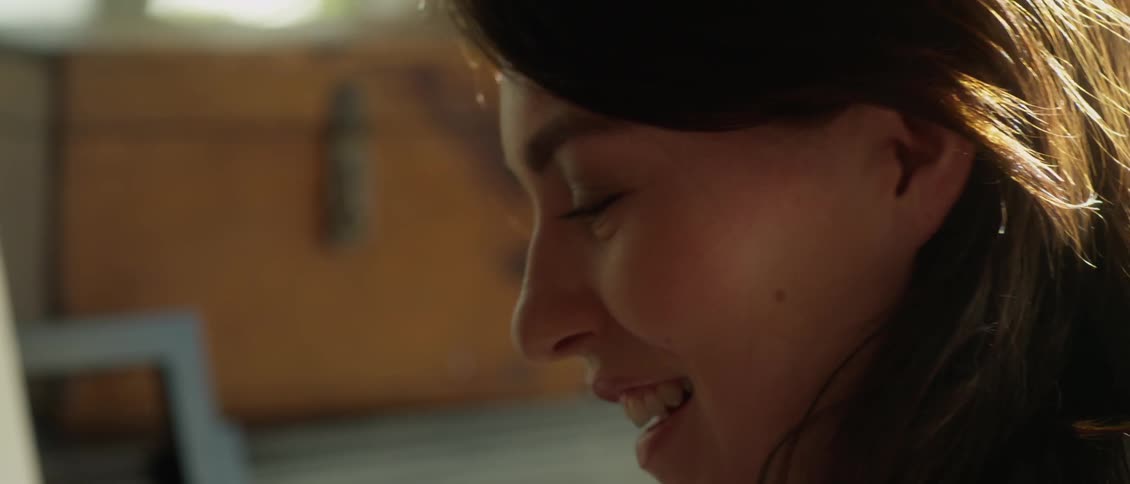 A woman smiles talking with someone next to her