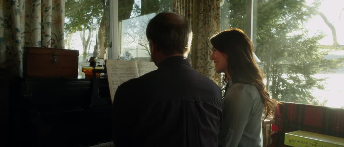 Man and woman look at sheet music together on a sunny day
