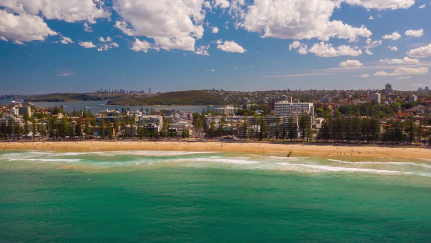 Aerial time lapse of a coastal city with a large beach next to it
