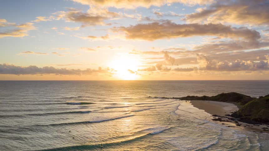 The tide is hitting the shore at sunrise