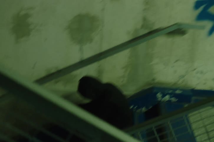 Person sits on the steps of a staircase covered in graffiti