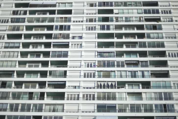 A white high rise apartment building with many levels