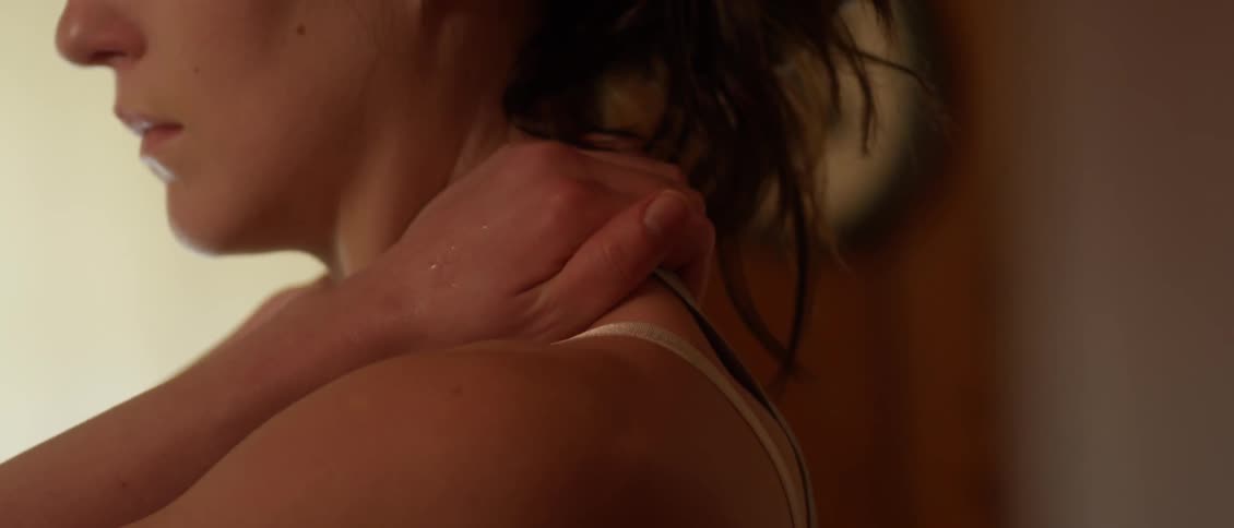 A woman rubs her shoulders
