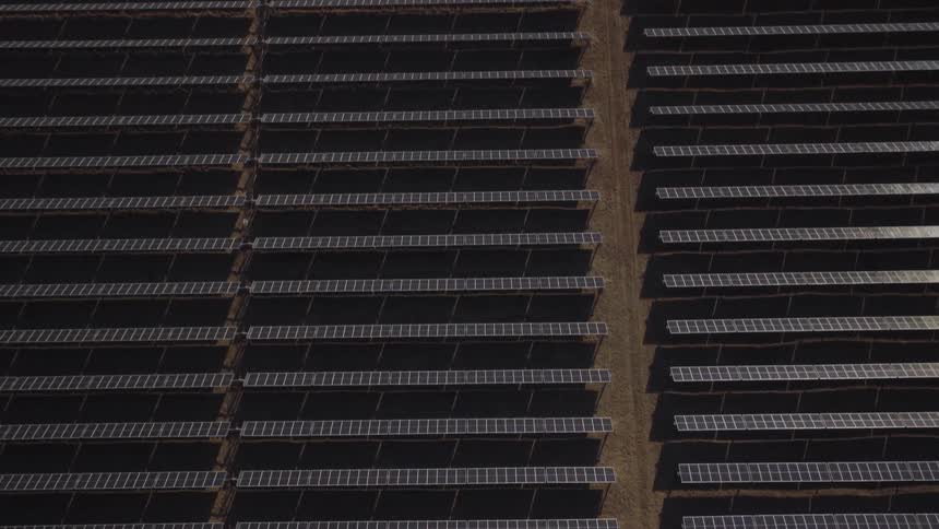 An aerial view captures rows of solar panels installed in a field