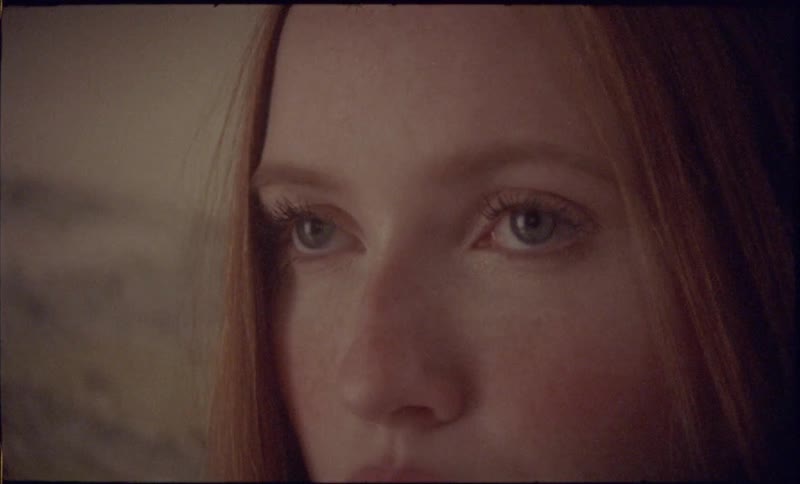 A woman raises her eyes and keeps her expression neutral