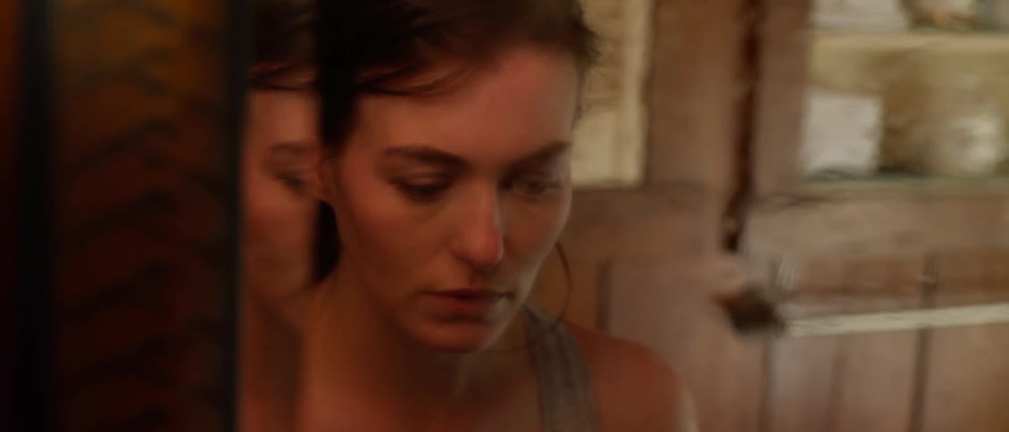 Sad looking woman looks at herself in the mirror