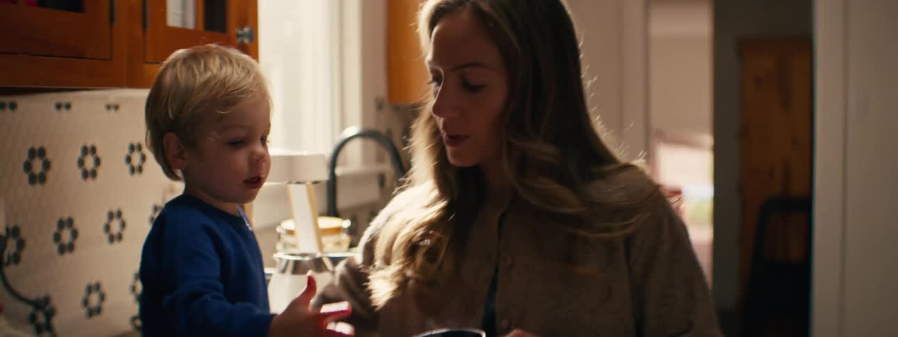 The woman hands a man a cup of coffee at home
