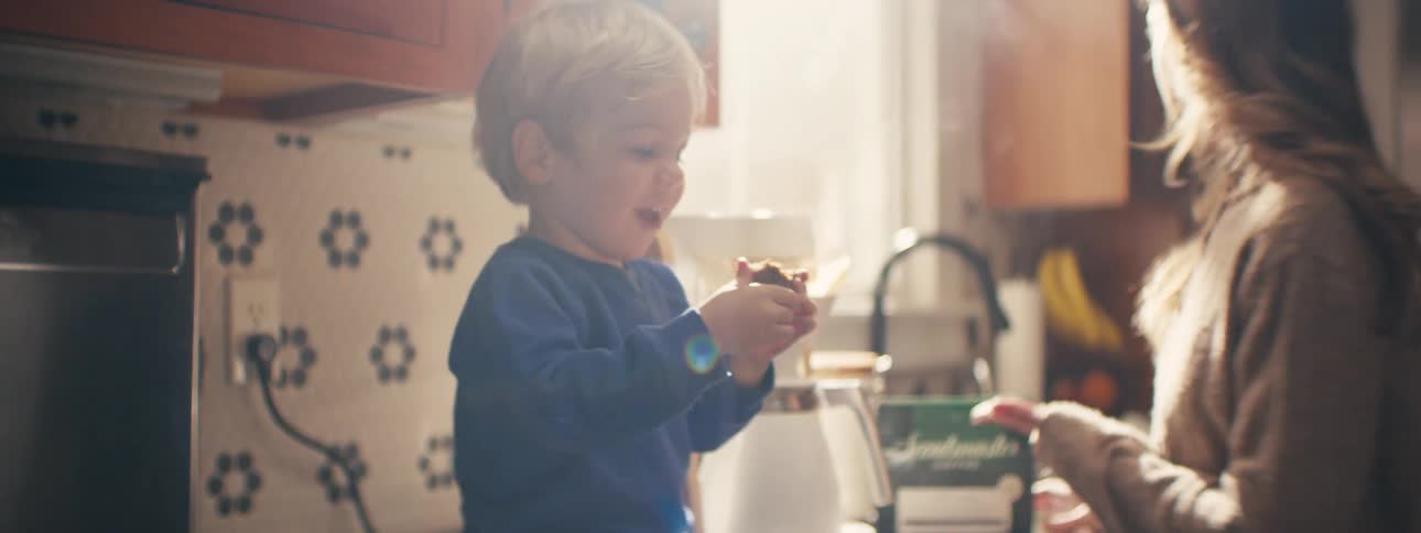 Boy hands his mother a bag of ground coffee and receives a piece of cake
