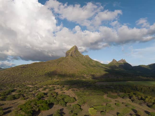A view of a mountain with clouds above it