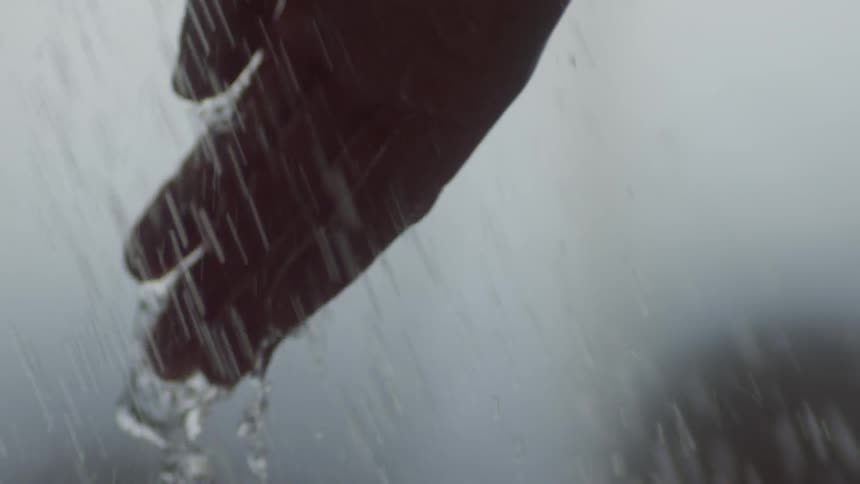 Person runs their hand through spraying water