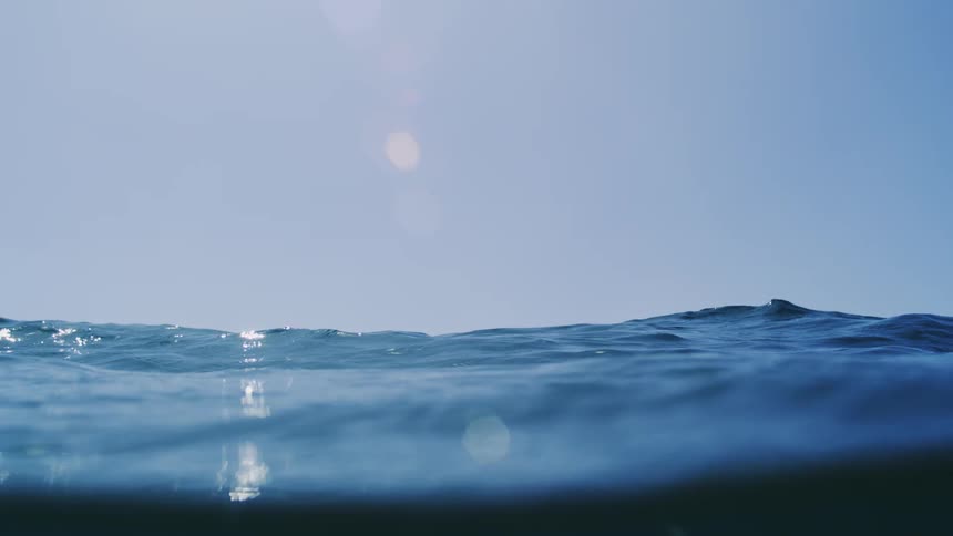 Ocean waves seen at water level under a clear sky