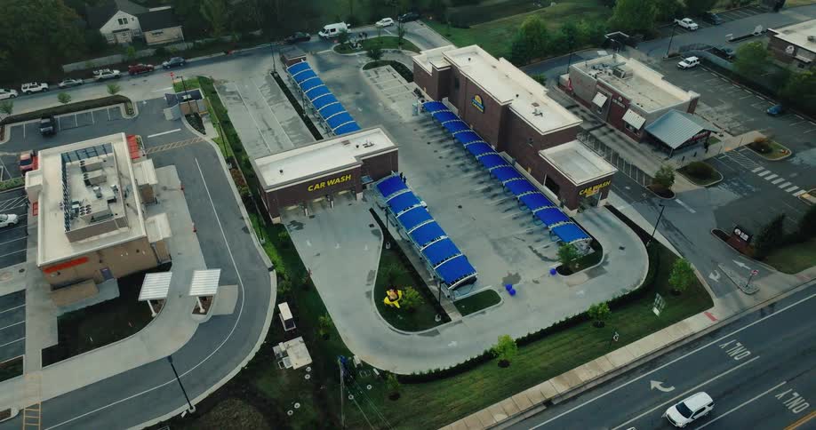 Aerial view of a car wash facility with multiple covered bays