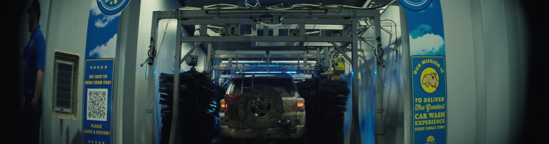 Utility vehicle passes through rotating brushes during automatic wash