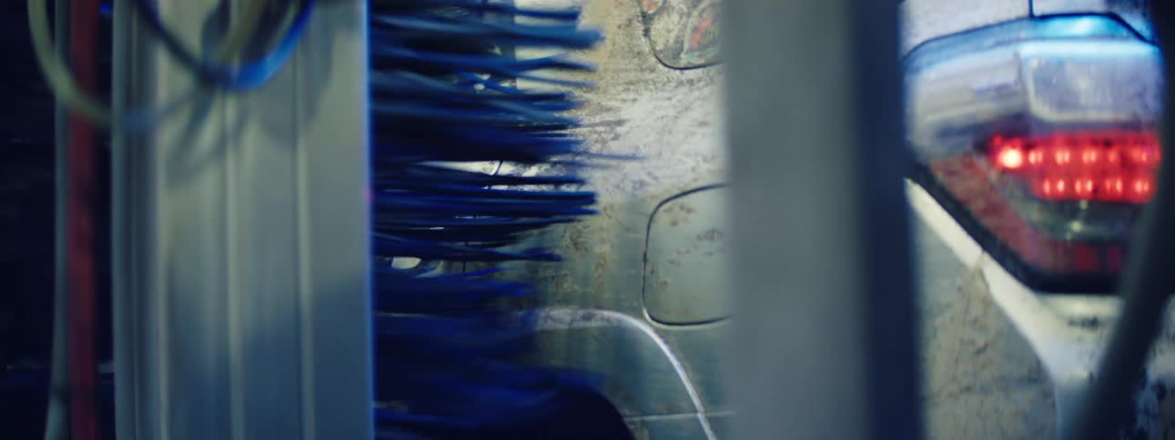 Rotating brush of an automatic machine cleaning the side of a car