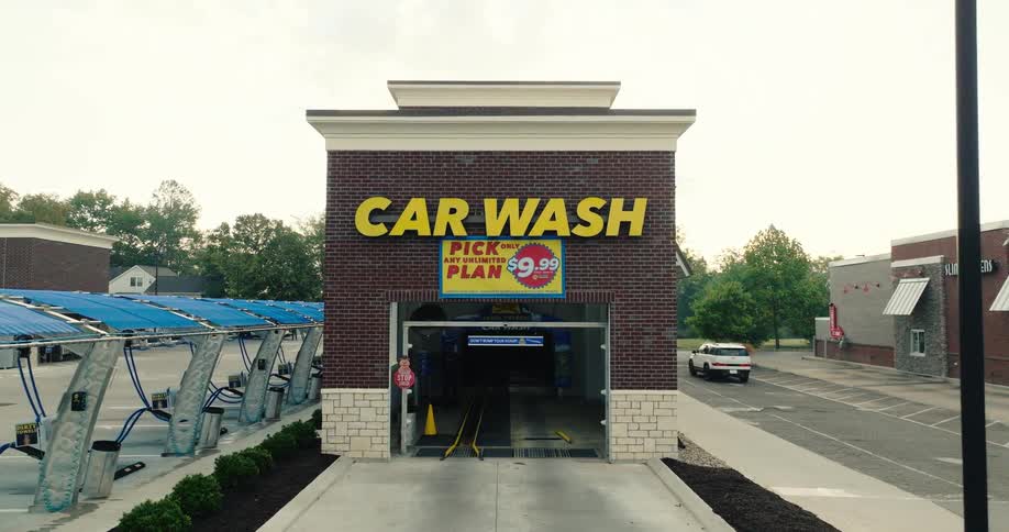 Automatic car wash entrance in a brick building with a car wash sign