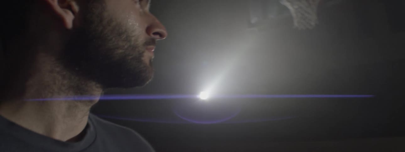 A sweating man turns and looks at a basketball backboard