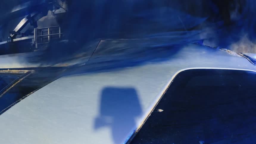 Rotating brush of an automatic machine cleaning a car body