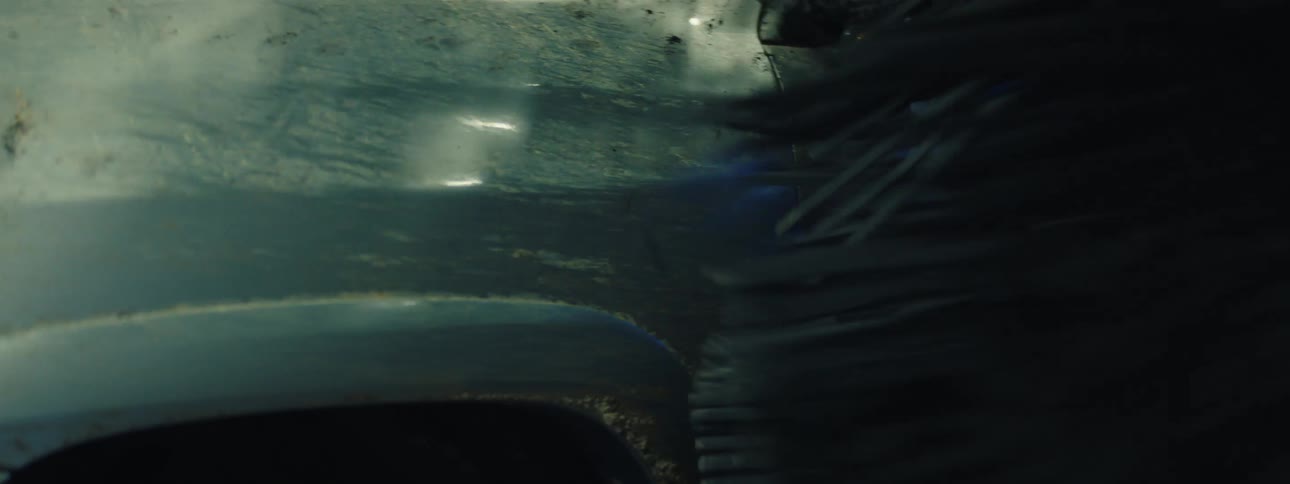 Rotating brushes clean the front of a vehicle during an automatic wash