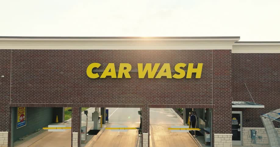 Front of a car wash facility with three entrances under a car wash sign