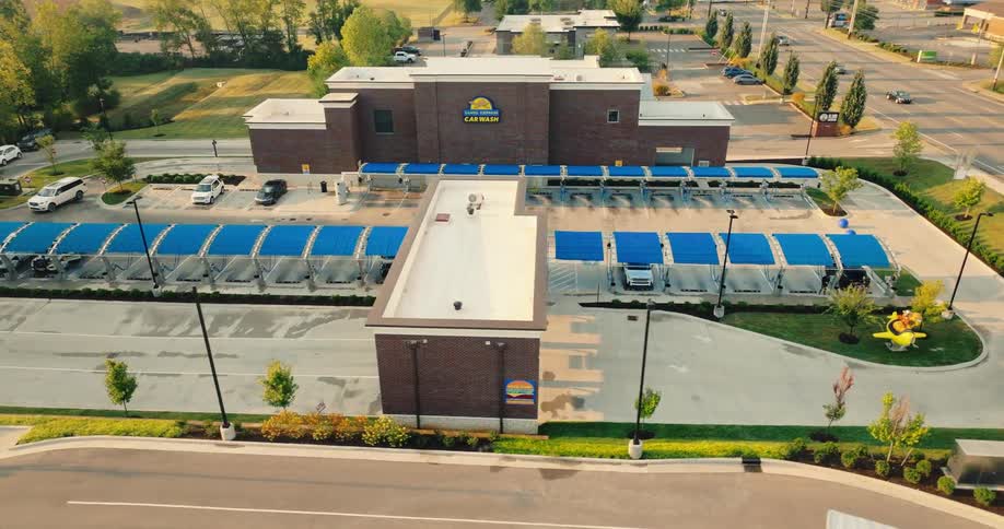 Aerial view of a car wash facility with multiple covered bays and service buildings