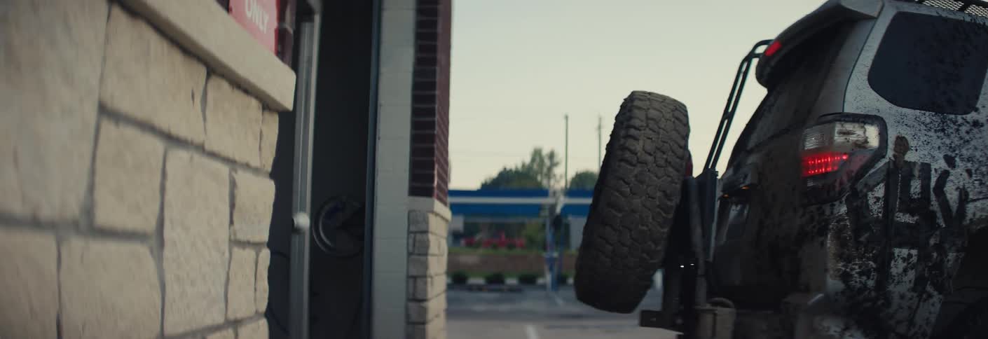 An old car drives out of a building