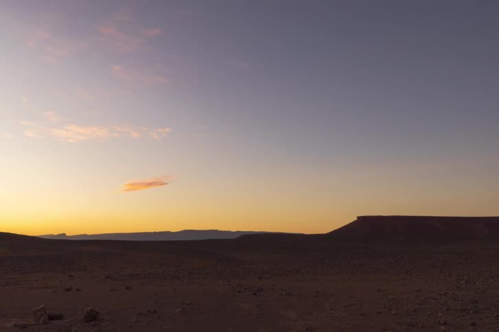 A view of a landscape with sun setting in the distance