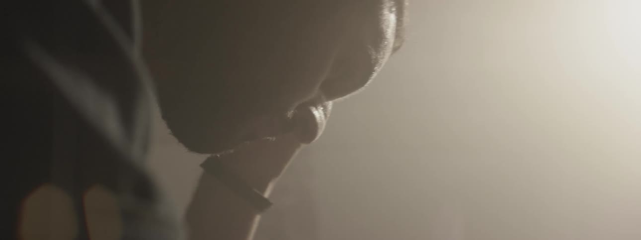 Sweat drips off a seated man rubbing his head