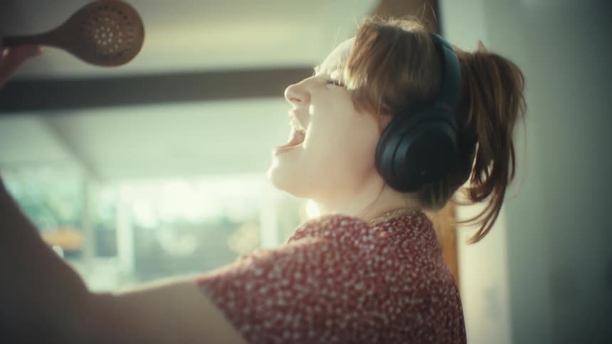 A woman standing in a room singing