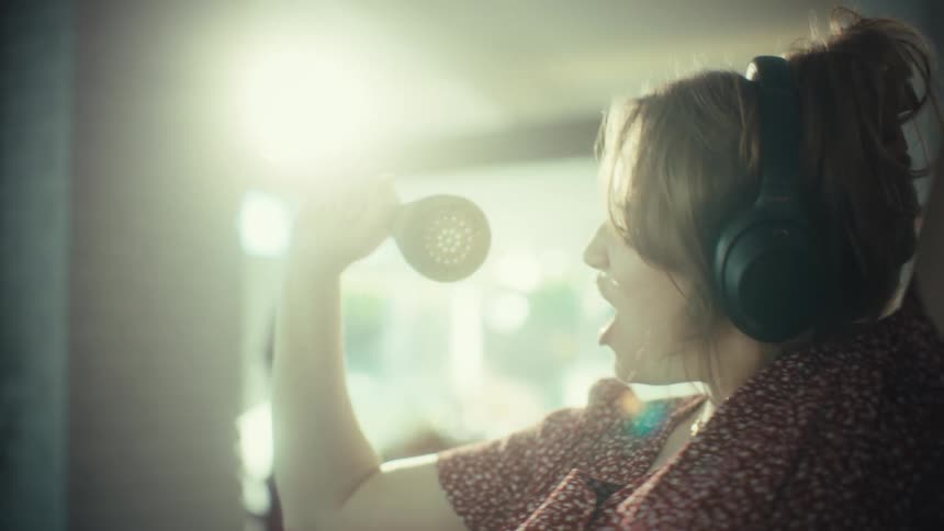 Woman dancing with headphones and kitchen utensil