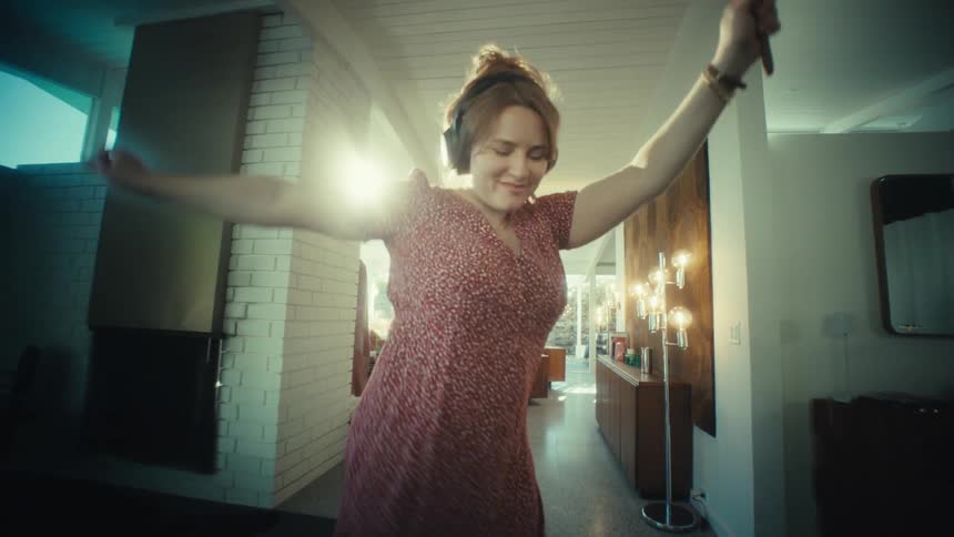 Person dancing with headphones in indoor setting