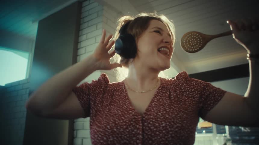 A woman singing into a spoon