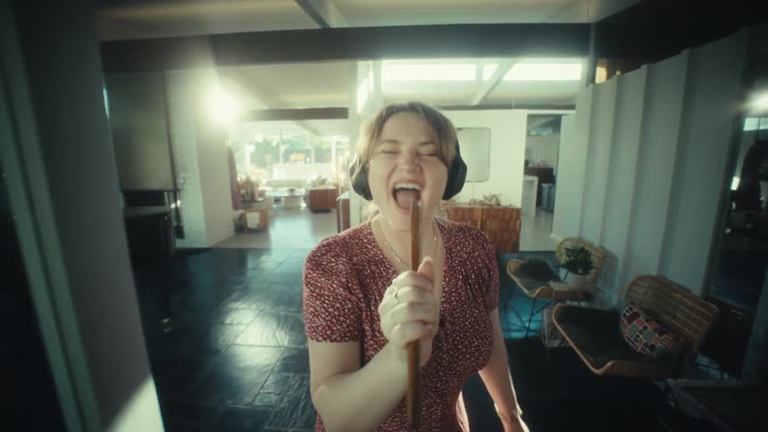 A woman singing into a spoon