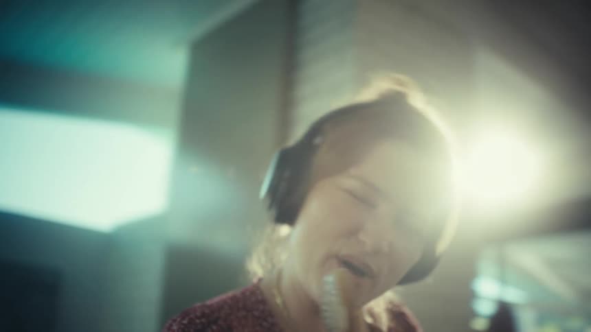 Woman singing with headphones and wooden spoon