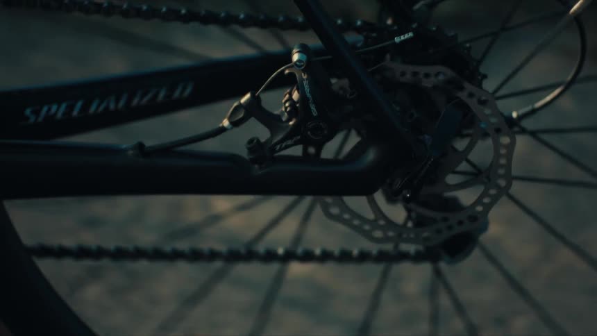 Bicycle chain and disc brake seen up close in motion