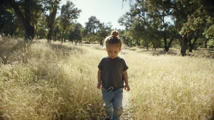 Little girl walking along a trail during the day