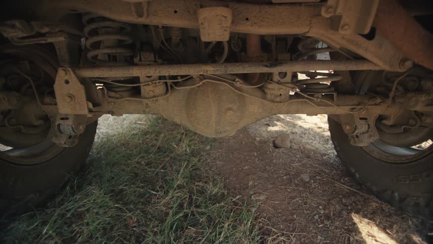 Underside of a moving vehicle on a dirt road