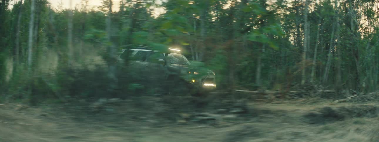 Pickup truck speeding down a forest trail