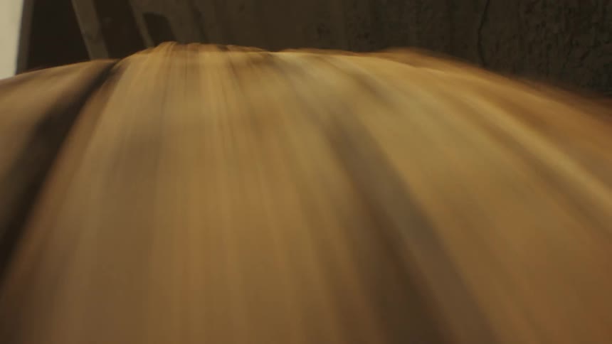 The camera focuses on a heavyduty offroad tire spinning rapidly as dirt and dust are kicked up by the aggressive treadthe lowangle shot captures the interplay of light and shadow on the rubber surfaces while motion blur turns the deep gr