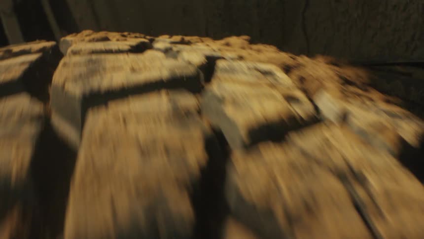 The camera provides an extreme closeup of a rugged offroad tire spinning rapidly through thick mud with clumps of dirt flying off the deep treads as the vehicle navigates the rough terrain